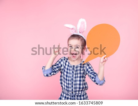 Easter Sale Banner. Easter portrait of a cute little girl with space for text, isolated pink background. Dressed in a blue plaid dress with a Hoop with Bunny ears. The concept of Easter holidays.