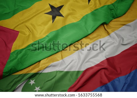 waving colorful flag of comoros and national flag of sao tome and principe . macro