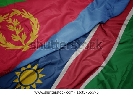 waving colorful flag of namibia and national flag of eritrea. macro