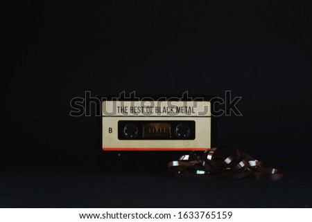Old audio tape and text "The Best of Black Metal" on it on a dark background