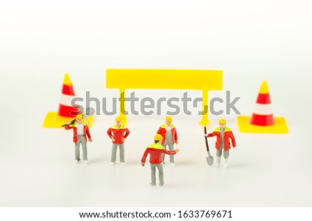 Foreman and worker Responsibility meeting next to traffic cone and caution sign to finish the project