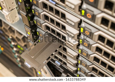 Powerful computer equipment works in the server room of the data center. Array of database servers with many hard drives and service tag. Space for text at service tag. Selective fo?us