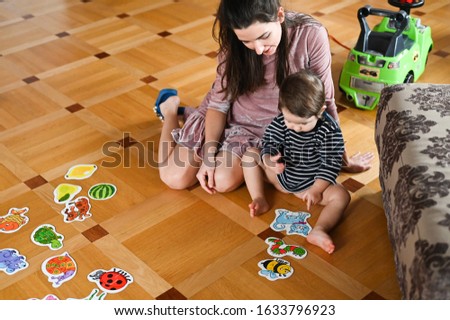 The child learns through pictures. Baby boy and insects. Mom and baby study insects.