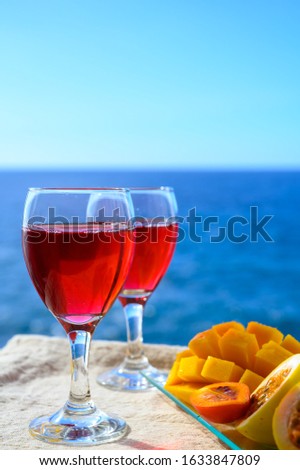 Two glasses of cold rose wine served outdoor with exotic fruits on tropical island La Palma, Canary islands, Spain with beautiful blue ocean view