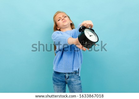 Beautiful girl holds an alarm clock