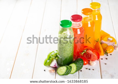 Selection of colorful gazpachoes on white wood background, copy space