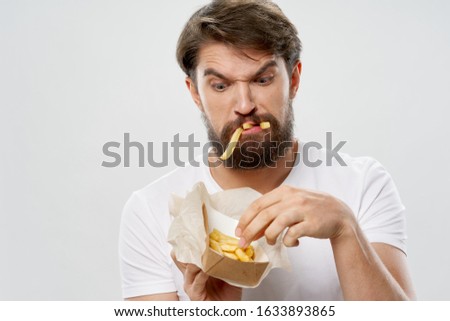 Man with french fries and emotions junk food