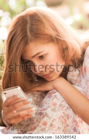 Lonely Beautiful girl playing smartphone