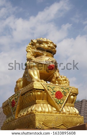 Goldren Chinese Guardian Lion (side view) in front of door entrance