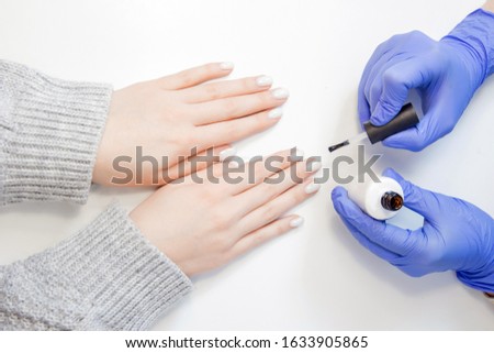Closeup beautiful hands woman getting drawing picture nail care manicure in spa salon, white background.