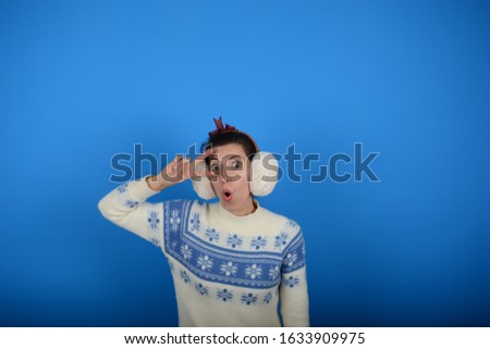 woman signs with fingers emotions surprise on a blue background