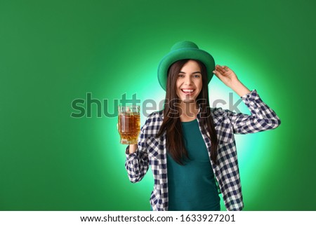 Young woman with beer on color background. St. Patrick's Day celebration