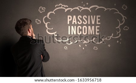 businessman drawing a cloud with PASSIVE INCOME inscription inside, modern business concept