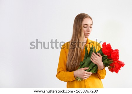 Conceptual image of a woman holding spring flowers as present for international women's day. Close up, copy space, background.