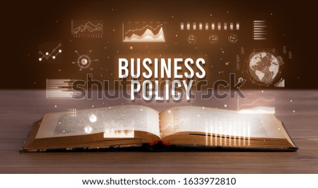 BUSINESS POLICY inscription coming out from an open book, creative business concept