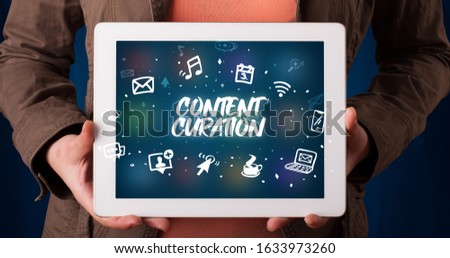 Young business person working on tablet and shows the inscription: CONTENT CURATION