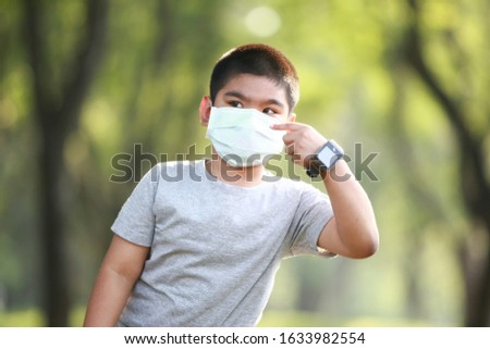 A young Asian boy wear mask to protect against dust PM 2.5 and germs Royalty-Free Stock Photo #1633982554