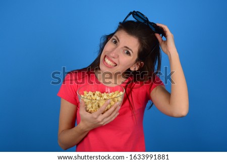 woman with 3D glasses holds popcorn in her hands