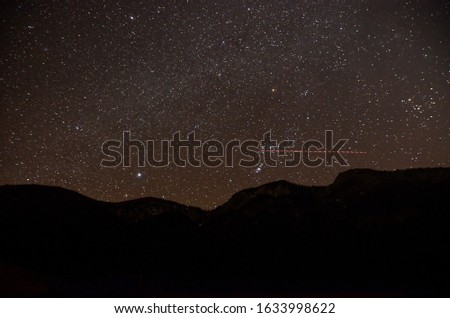 Night Sky Stars.  Black dark night with many stars on the sky. Space background. Long exposure of mountains in nature. Summer night with beautiful sky. Natural real night sky stars, texture.  
