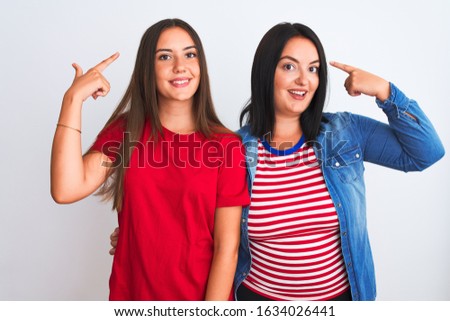 Young beautiful women wearing casual clothes standing over isolated white background smiling pointing to head with both hands finger, great idea or thought, good memory