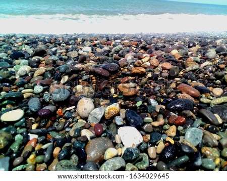 Colorful saturated sea stones on the shore of the Black Sea in Batumi, Georgia. Sea background