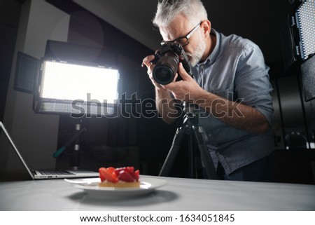 Photographer taking pictures in studio - food pack shot