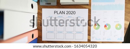 Top view on calendar for ideas and tasks for 2020. Table with documentation containing statistics. Calculator for business audit and accounting of profits and expenses of company