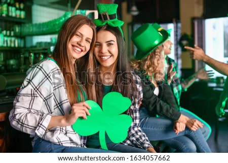 Young women celebrating St. Patrick's Day in pub Royalty-Free Stock Photo #1634057662