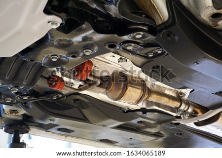 A catalyst is installed on a modern car to reduce the amount of harmful emissions. Modern solutions and technologies in cars to protect the environment. Quality spare parts and service concept. Royalty-Free Stock Photo #1634065189