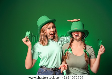 Funny young women on color background. St. Patrick's Day celebration Royalty-Free Stock Photo #1634072707