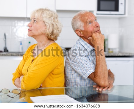 Portrait of upset mature couple discussing, quarrel at home interior Royalty-Free Stock Photo #1634076688
