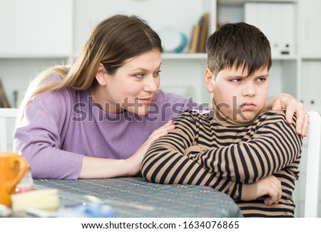 Mother wants to talk with his son after  conflict at table  in kitchen Royalty-Free Stock Photo #1634076865