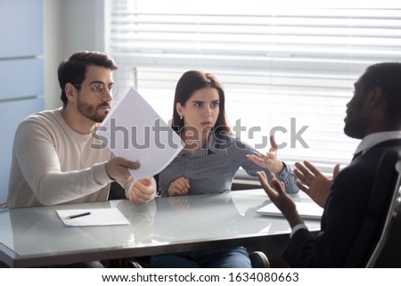 Annoyed clients couple arguing with bank manager dissatisfied by high mortgage rate, legal fight and fraud, demand of compensation, business partners unhappy with contract, claiming money back concept Royalty-Free Stock Photo #1634080663