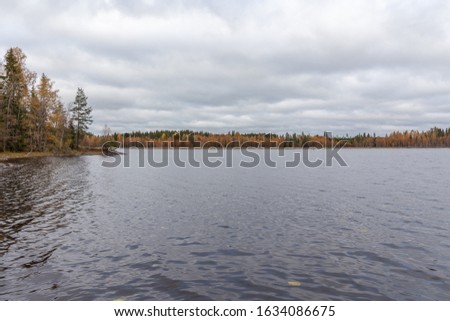 cloudy sky over the lake. Autumn forest in the background, Central Sweden, selective focus