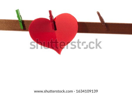 Red paper hearts on clothespins on a white background. Valentine's day concept.