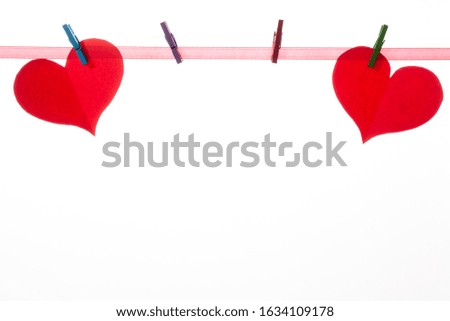 Red paper hearts on clothespins on a white background. Valentine's day concept.