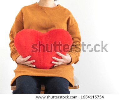 Pregnant woman with big stomach and heart cushion