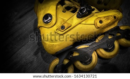 yellow roller skates on a wooden surface, fragment, blurred background