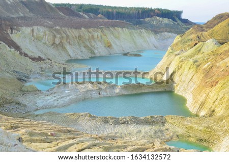 Chalk mining in an industrial quarry at Krasnoselsky village in the Belarus. Mountain lake or river with a turquoise or blue tint of water in a rock canyon.  Turquoise background of the clear river