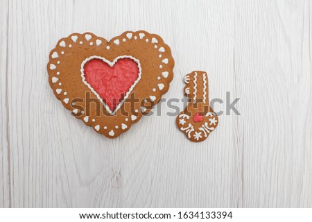 Heart shaped gingerbread with key figure on wooden background 