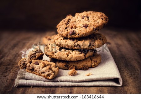 Chocolate cookies on white linen napkin on wooden table. Chocolate chip cookies shot on coffee colored cloth, closeup. Royalty-Free Stock Photo #163416644