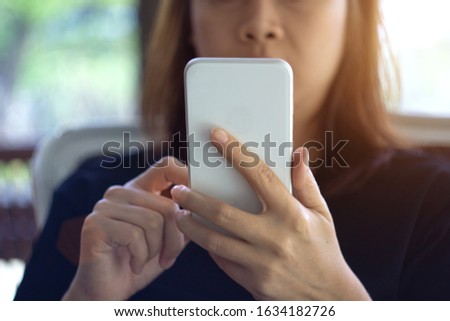 Focus hand of Young asian woman touching smartphone, Young female use smartphone for chat and surfing the Internet - Sunset filter effect