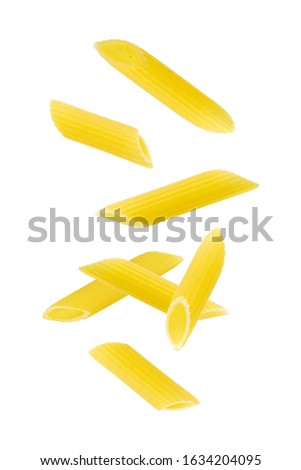Falling penne pasta. Flying yellow raw macaroni over white background.