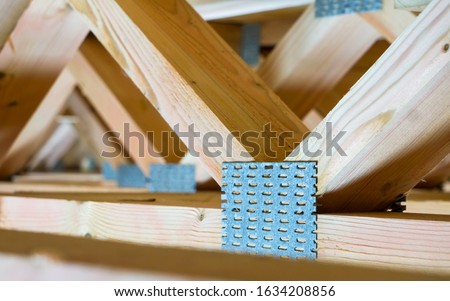 open web design wooden floor trusses closeup in framed construction made with steel connector plates Royalty-Free Stock Photo #1634208856