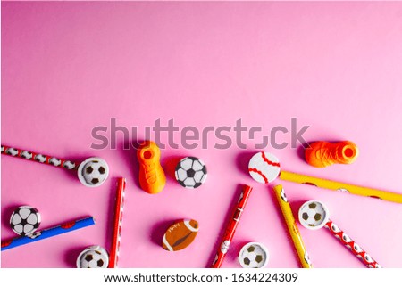 set of pencils and erasers on a pink background