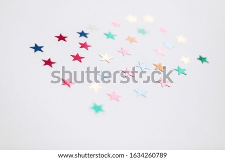 Colorful stars confetti or glitter on white background. Party backdrop. Stylish atmospheric image. Happy birthday concept. Holiday decorations. Magic and Christmas.