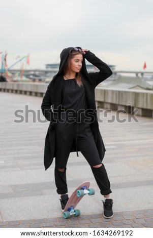 Young woman down the road on a skateboard