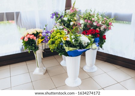 Gift wedding bouquets in a cellophane wrapper of garden flowers in floor vases. Photography, concept.