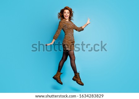 Full body photo of candid cute pretty vogue style woman jump enjoy rest relax make v-sign scream wear season shoes cotton tights isolated over blue color background