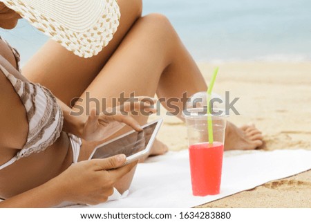 Young woman is using tablet pc on the beach 